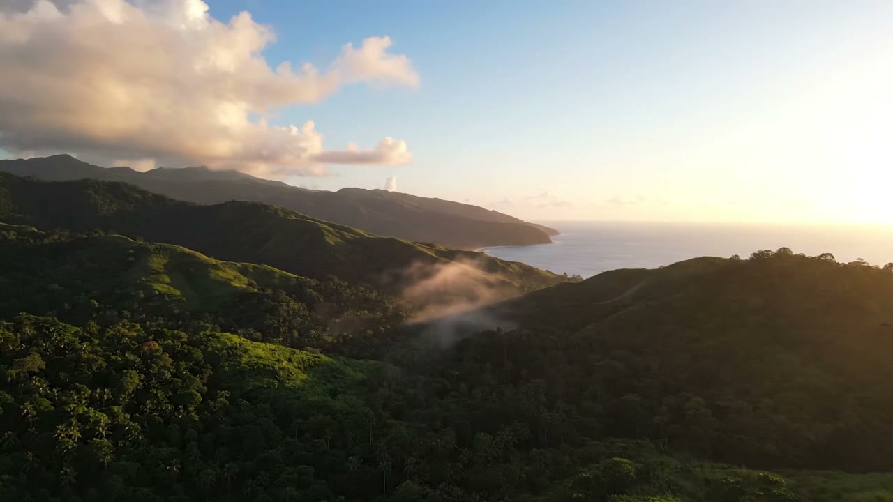 Golden-hour light over the rolling St. Mary coastline, mist settling in the valleys